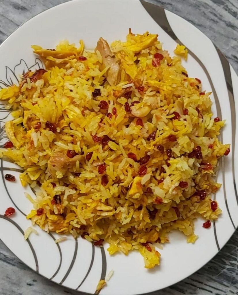 A round Chinese-style plate filled with mixed Zereshk Polo, featuring saffron rice, barberries, and chicken