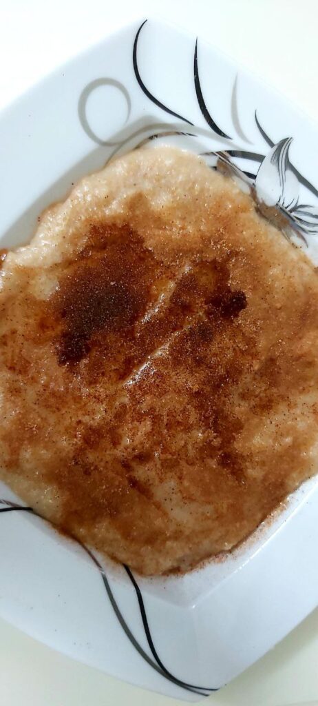 Chinese plate with a bowl of halmee topped with healthy oil, sugar, and cinnamon for a balanced breakfast