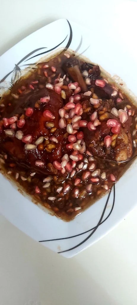 Braised chicken in pomegranate molasses topped with fresh pomegranate seeds – a traditional Persian dish known as Nardoon.