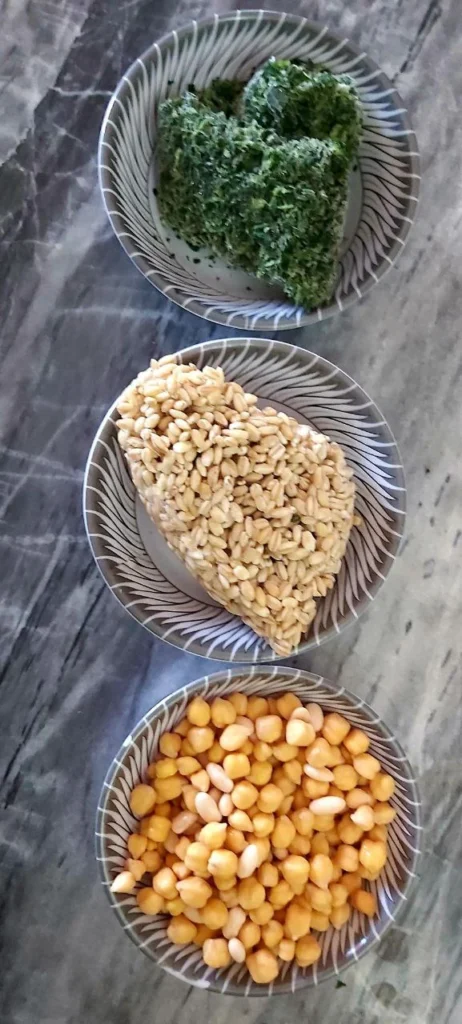 Three bowls containing hulled barley, chickpeas, and spinach for barley yogurt soup