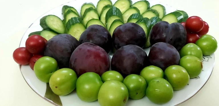 A close-up of cucumber slices with red and green vegetables, symbolizing fresh and healthy eating habits.