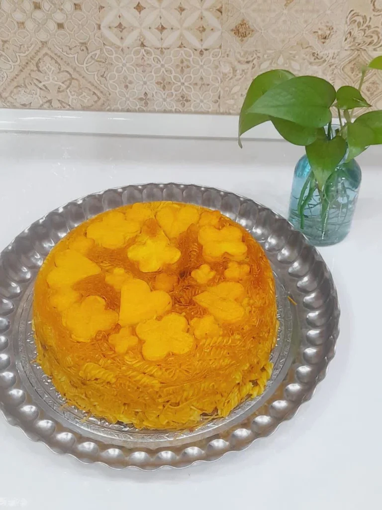 Molded Iranian macaroni with heart and flower-shaped golden potato tahdig on a large serving tray