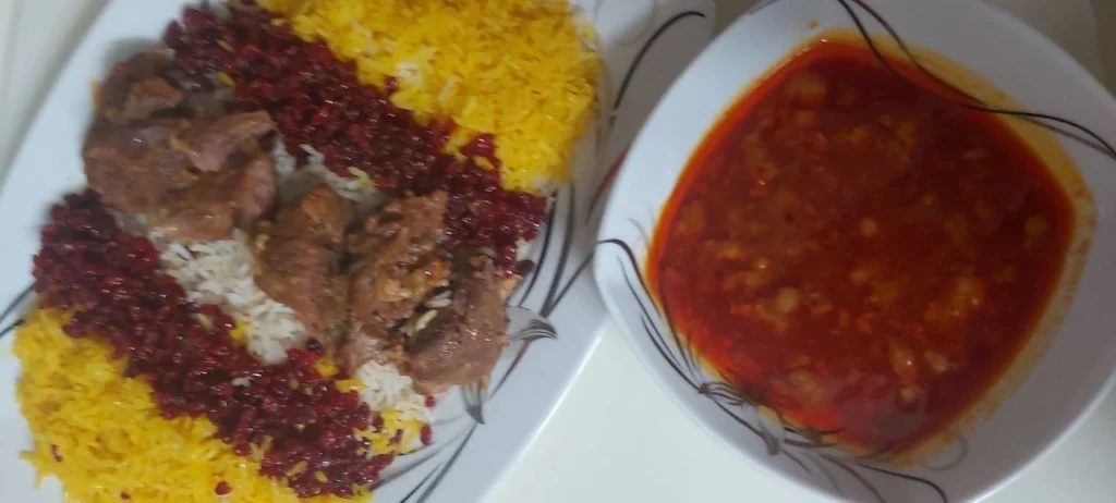 Chelo Gosht platter with lamb and saffron rice, served beside a square bowl of lamb stew broth