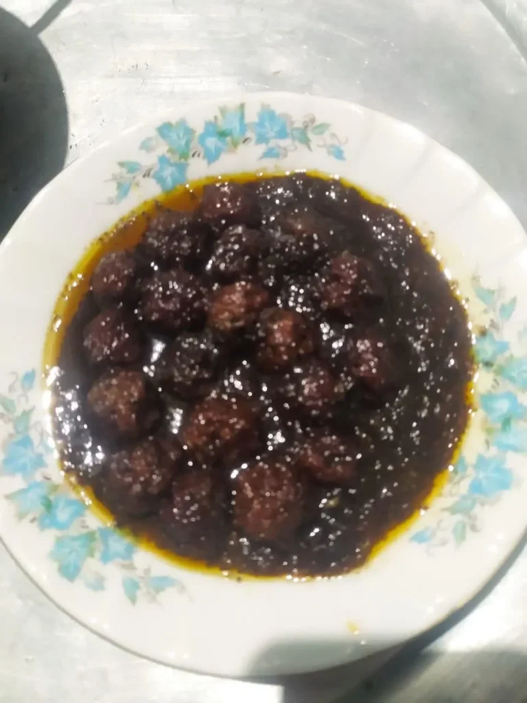 Khoresh Davood Pasha meatball stew in a white plate with blue flower design.