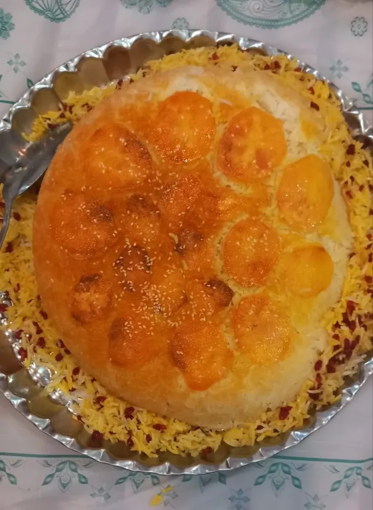Close-up of a perfectly golden-brown and crispy Persian potato tahdig, with slices of potato forming a beautiful pattern at the bottom of the rice. The texture is visibly crunchy, suggesting a delicious crust.